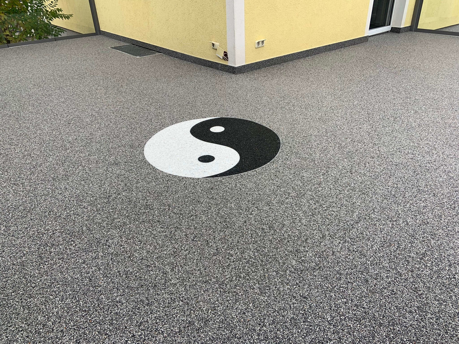 Natursteinteppich mit Yin und Yang-Logo